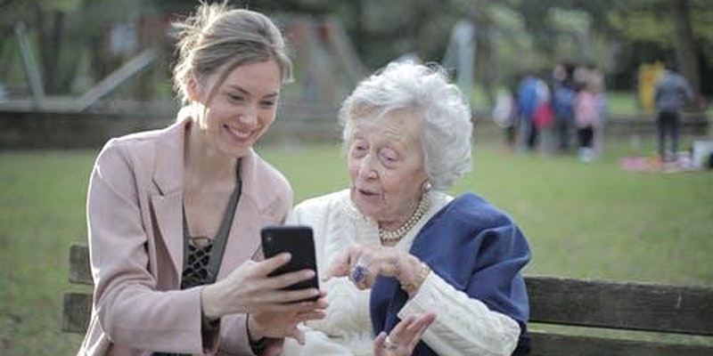 woman showing her phone to woman