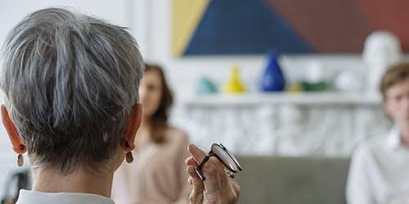 Woman holding glasses while doing therapy