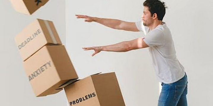 man pushes cardboard boxes
